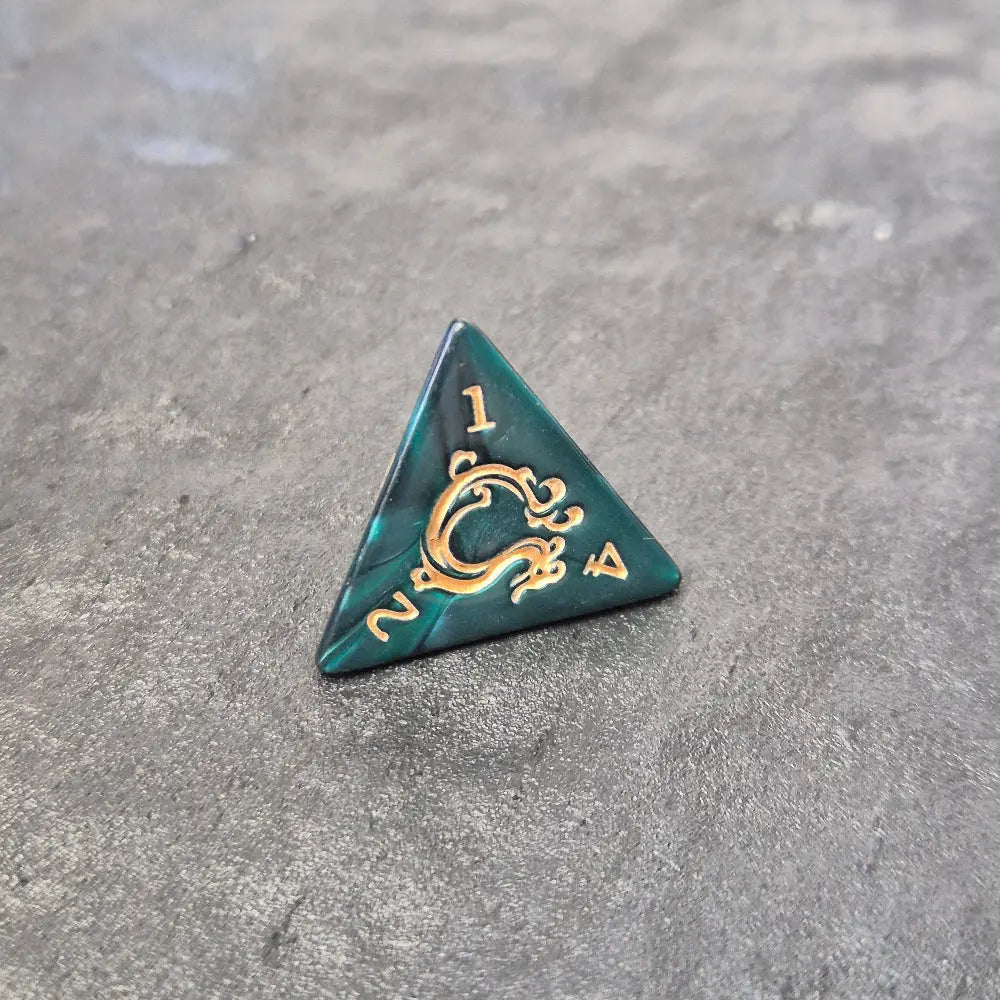 Acrylic D4 with emerald green swirls and antique gold arcane-style numbering, displayed on a textured dark surface.
