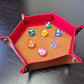 Foldable hexagon-shaped dice trays in red & brown shown open and filled with colorful polyhedral dice.