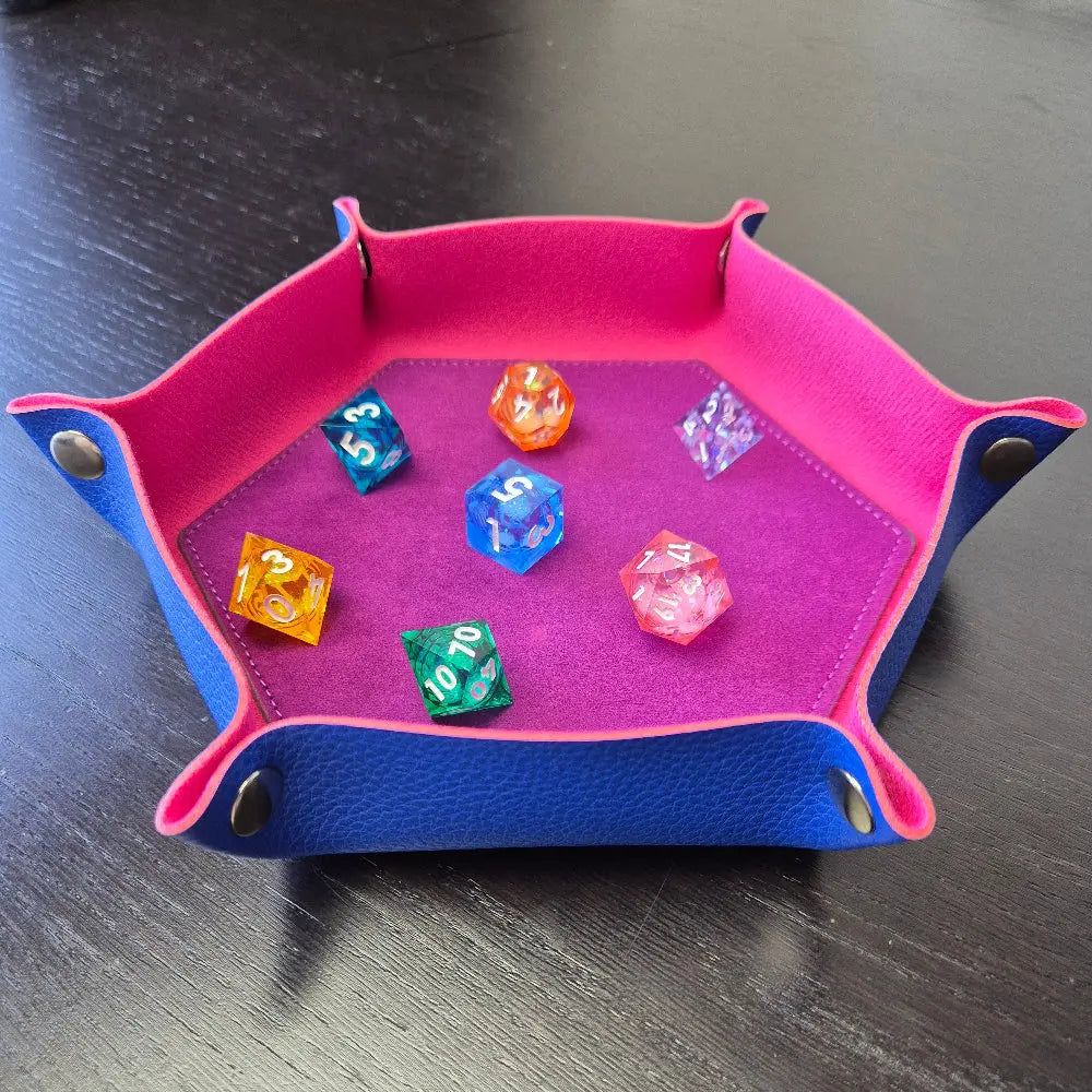 Foldable hexagon-shaped dice trays in pink & purple shown open and filled with colorful polyhedral dice.